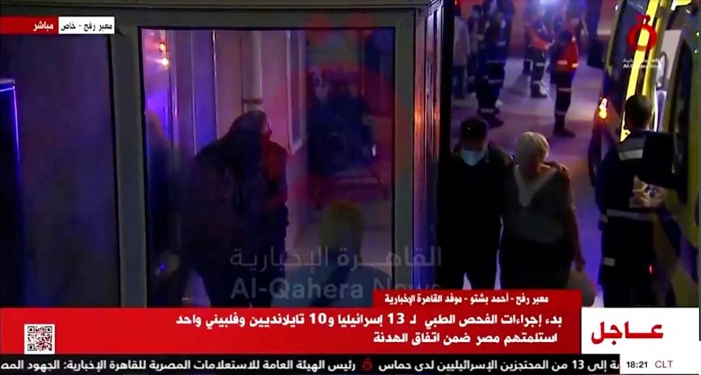 People disembark a vehicle, as a convoy of vehicles carrying hostages arrives through the border crossing with Gaza, amid a hostages-prisoners swap deal between Hamas and Israel, in Egypt on Friday. Al Qahera News/Reuters TV via REUTERS.