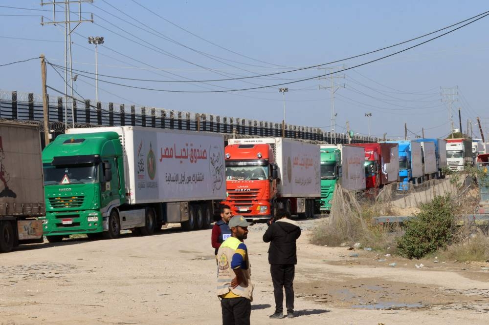 Trucks carrying humanitarian aid enter the Gaza Strip via the Rafah crossing with Egypt, hours after the start of a four-day truce in battles between Israel and Hamas, Friday.
