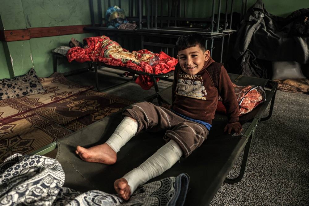 Muhammad Abu Wardeh, 9, lies injured in a classroom at the Ras Al-Naqoura school in Khan Yunis in the southern Gaza Strip, after being transferred from the Indonesian Hospital in the north, on November 22. AFP