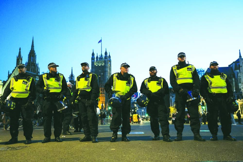 
Police officers stand guard near the Palace of Westminster in Whitehall, as people protest in solidarity with Palestinians in Gaza, during a temporary truce between Hamas and Israel, in London. 
