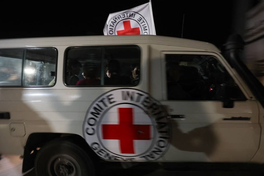 A Red Cross vehicle, as part of a convoy believed to be carrying hostage arrives at the Rafah border, amid a hostages-prisoners swap deal between Hamas and Israel, in southern Gaza Strip Saturday late night. REUTERS