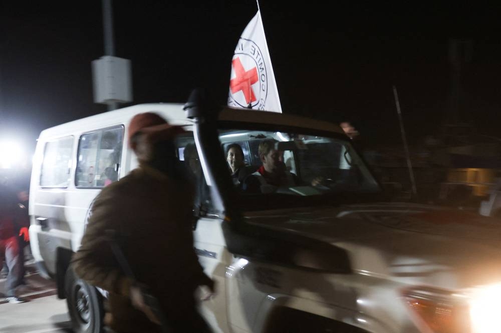 A Red Cross vehicle, as part of a convoy believed to be carrying hostage arrives at the Rafah border, amid a hostages-prisoners swap deal between Hamas and Israel, in southern Gaza Strip Saturday late night. REUTERS