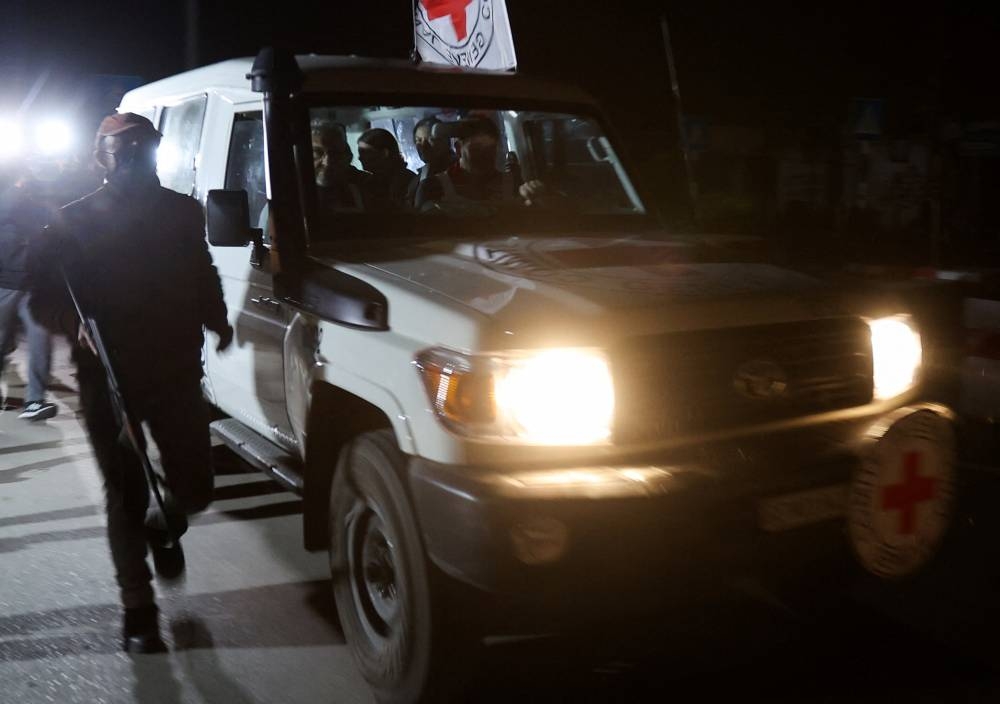 A Red Cross vehicle, as part of a convoy believed to be carrying hostages arrives at the Rafah border, amid a hostages-prisoners swap deal between Hamas and Israel, in southern Gaza Strip Saturday night. REUTERS