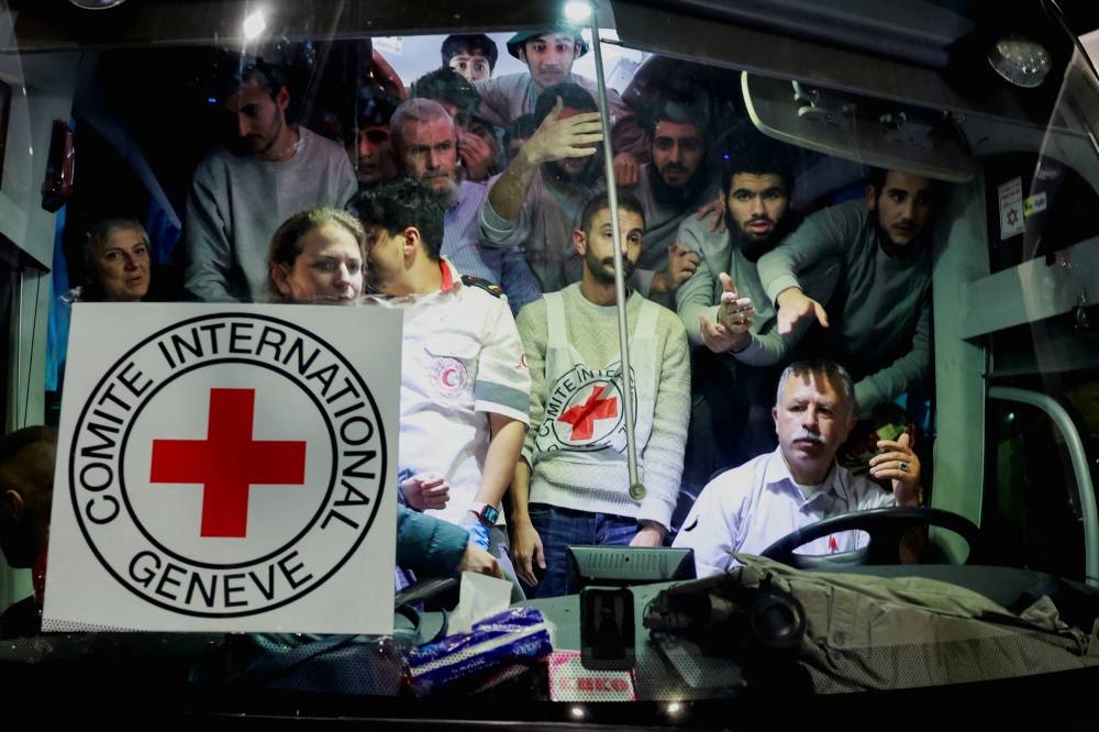 Released Palestinian prisoners react from inside a vehicle after leaving the Israeli military prison, Ofer, near Ramallah in the Israeli-occupied West Bank on Sunday. REUTERS