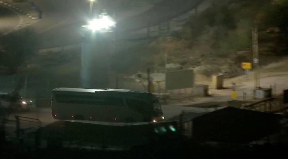 A bus leaves Israel's Ofer prison, where palestinian prisoners are expected to be released, amid a hostages-prisoners swap deal between Hamas and Israel, Sunday. Reuters TV/via REUTERS