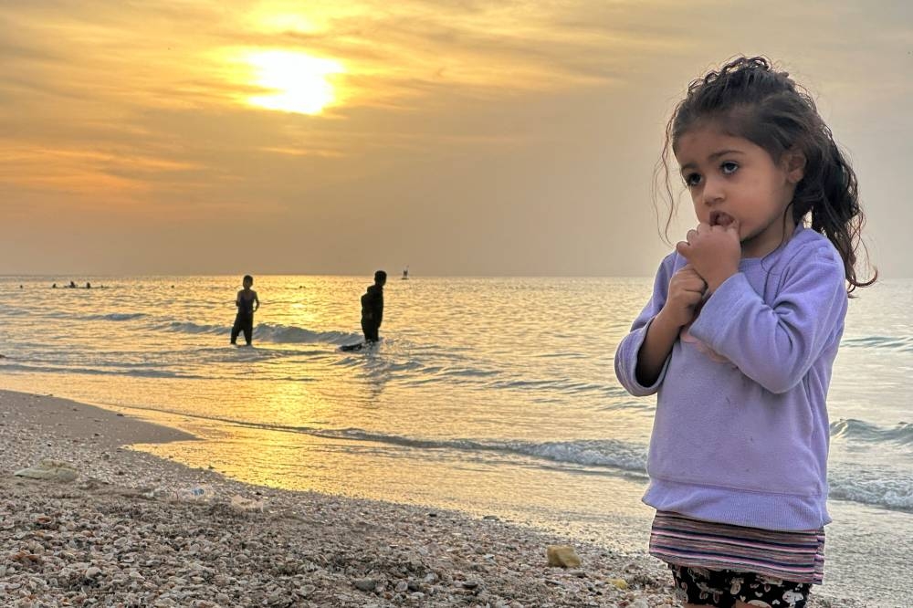 A child stands on a beach as Palestinians spend time on a beach during a temporary truce between Hamas and Israel, in Deir al-Balah in the central Gaza Strip Saturday. REUTERS