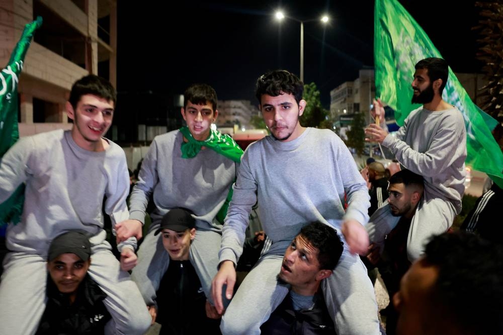 Released Palestinian prisoners react as they leave the Israeli military prison, Ofer, amid a hostages-prisoners swap deal between Hamas and Israel, in Ramallah in the Israeli-occupied West Bank on Sunday. REUTERS