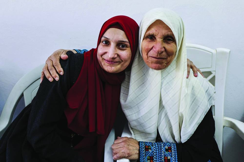 
Palestinian former prisoner Maysoon al-Jabali (left), who was jailed in Israel since 2015, greets her mother upon her arrival at her home in Al-Shawawreh village near the occupied West Bank city of Bethlehem, yesterday. 