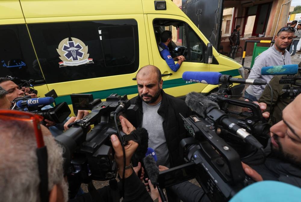 Hamada Abo Gazer speaks to the media, as ambulances transporting the bodies of people who died while receiving medical treatment in Egypt, including Hamada's father Mamdouh, wait to cross into Gaza, at the Rafah border crossing between Egypt and the Gaza Strip, during a temporary truce between Hamas and Israel, in Rafah, Egypt, Monday. REUTERS