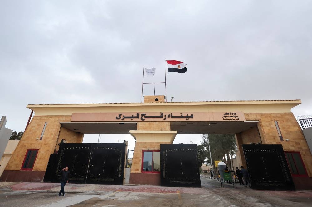 A man uses a phone at the Rafah border crossing between Egypt and the Gaza Strip, during a temporary truce between Hamas and Israel, in Rafah, Egypt, Monday. REUTERS