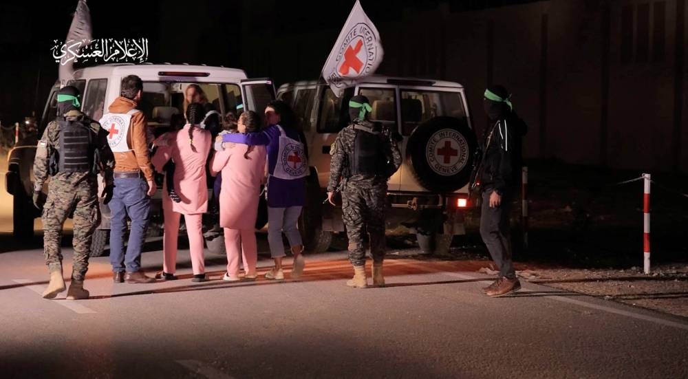 Hostages are handed over by Hamas to members of the International Committee of the Red Cross in an unknown location in the Gaza Strip, in this screen-grab taken from video released Monday. Hamas Military Wing/Handout via REUTERS