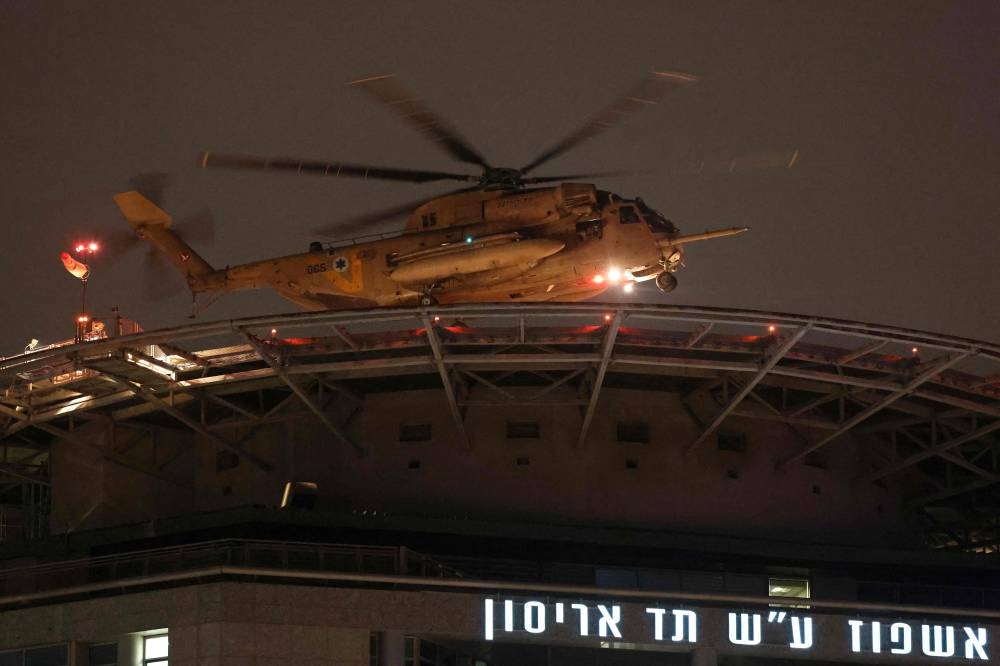 An Israeli helicopter transporting hostages, released by Hamas, prepares to land at the Tel Aviv Sourasky Medical Center in Tel Aviv on Tuesday. Photo by Jack Guez / AFP