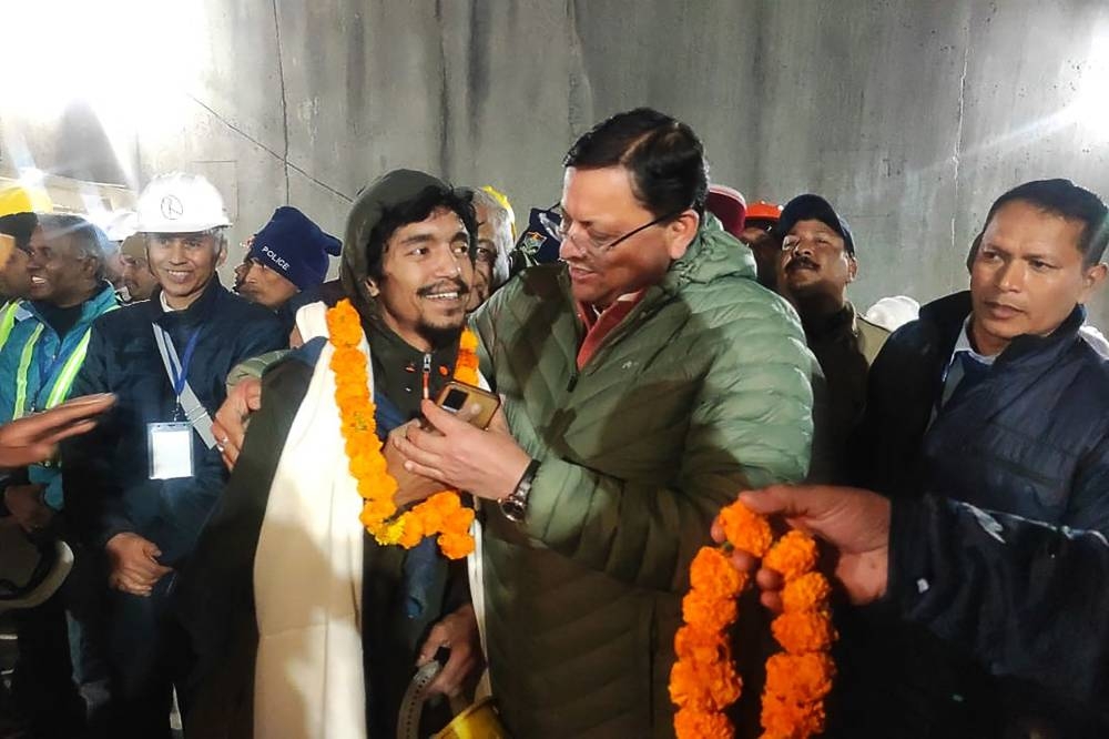 A contruction worker (front 2L) interacting with Chief minister of Uttarakhand Pushkar Singh Dhami (R) following his rescue from inside the under construction Silkyara tunnel during a rescue operation for trapped workers after a section of the tunnel collapsed in the Uttarkashi district of India's Uttarakhand state. AFP/ Department of Information and Public Relation, Uttarakhand