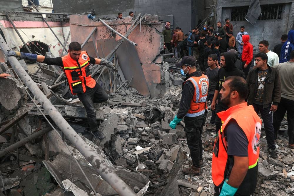 Palestinian medics search for survivors in the rubble of a building following Israeli bombardment in Rafah in the southern Gaza Strip, on Friday. AFP