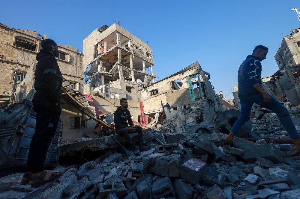 Palestinians inspect a building damaged during Israeli bombardment in Rafah, on the southern Gaza Strip, on Saturday. AFP