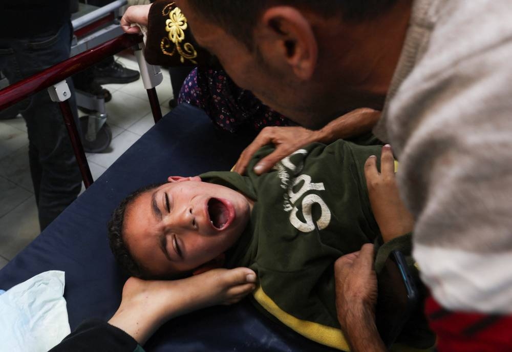 A Palestinian boy is assisted following an Israeli strike at Nasser hospital in Khan Younis in the southern Gaza Strip, on Sunday. REUTERS