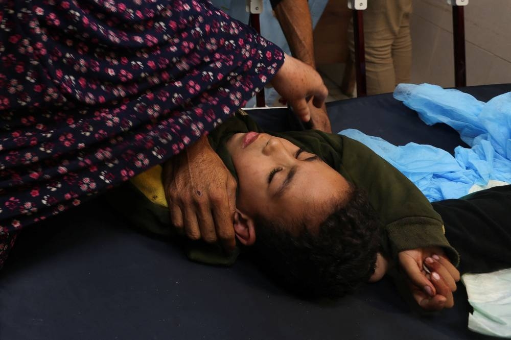 A Palestinian child lies on a bed after being rushed to the hospital following an Israeli strike at Nasser hospital in Khan Younis in the southern Gaza Strip, on Sunday. REUTERS