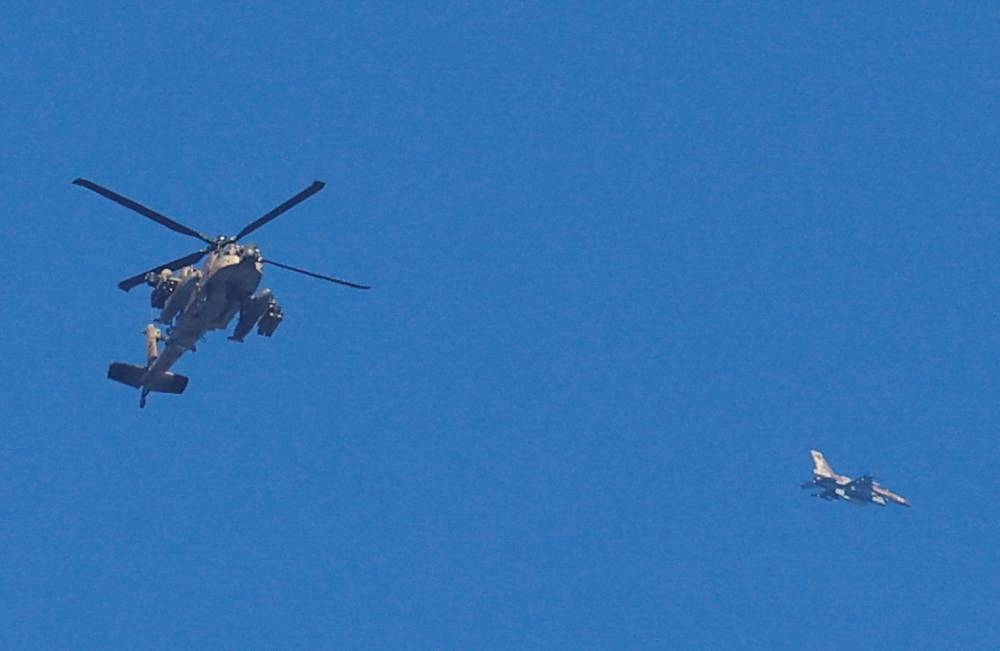 An Israeli military Apache helicopter and a jet fly close to the Gaza strip, on Sunday. REUTERS
