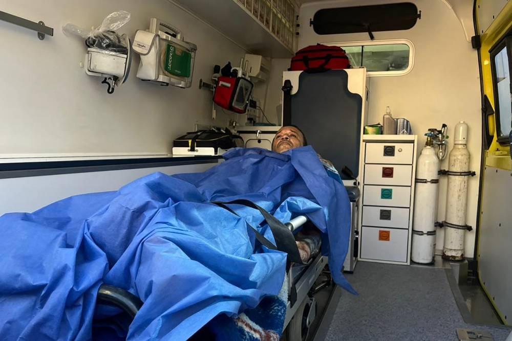 An injured Palestinian man lies in an ambulance on the Egyptian side of the Rafah border crossing on Monday. AFP