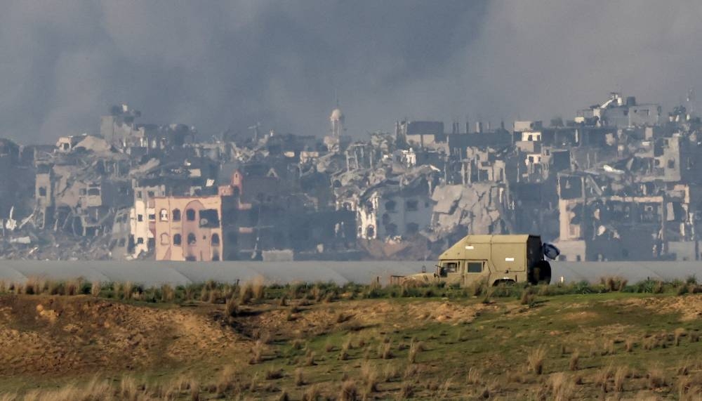 An Israeli military vehicle operates as smoke rises over Gaza as seen from southern Israel, on Wednesday. REUTERS