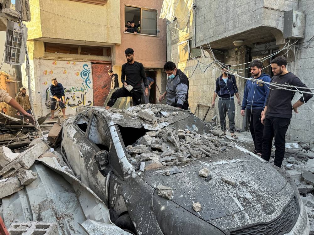Palestinians inspect a damaged car at the site of Israeli strikes on a house in Khan Younis in the southern Gaza Strip, on Friday. REUTERS