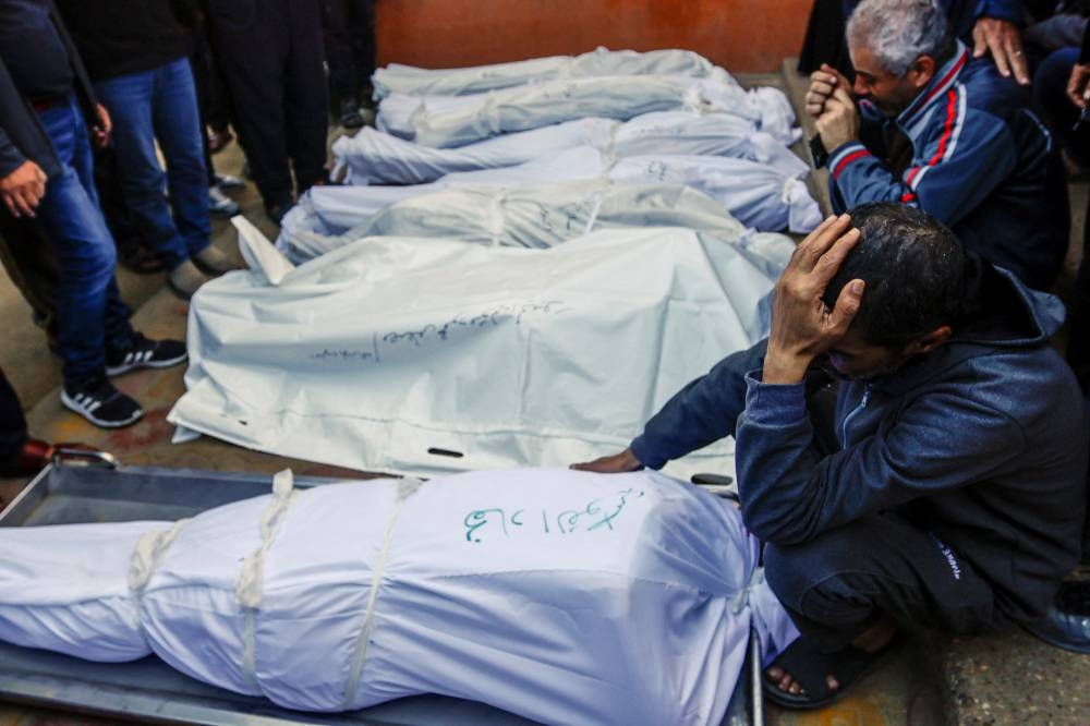 People mourn next to the bodies of Palestinians killed in Israeli strikes during a funeral at Nasser hospital in Khan Younis in the southern Gaza Strip, on Saturday. REUTERS