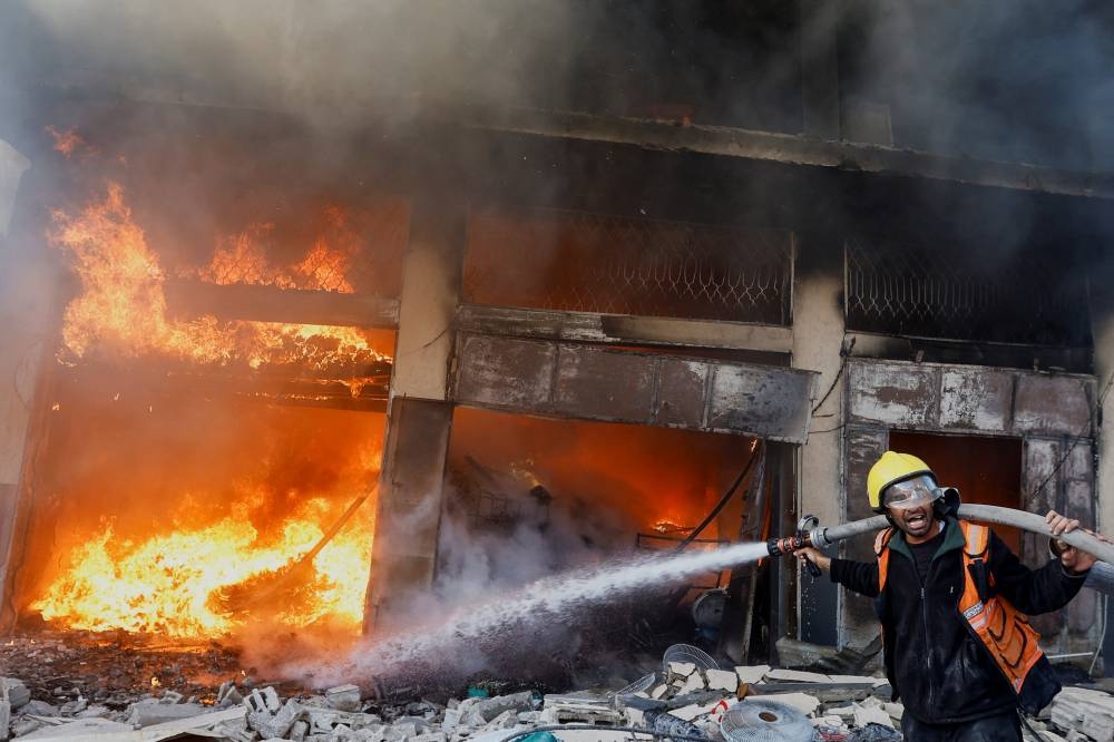 A Palestinian firefighter works to extinguish a fire in a house after an Israeli strike, in Khan Younis in the southern Gaza Strip, on Saturday. REUTERS