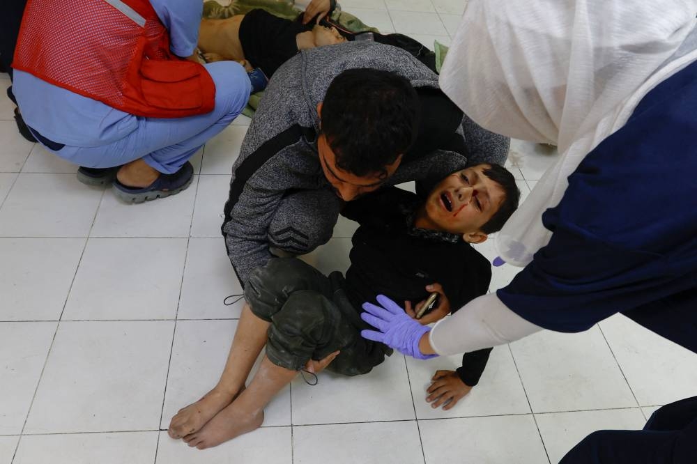 A wounded Palestinian child is rushed into Nasser hospital following Israeli strikes in Khan Younis in the southern Gaza Strip, on Friday. REUTERS