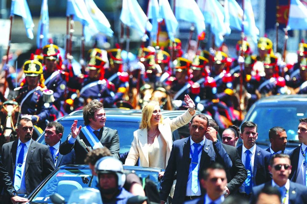 Milei and his sister Karina wave to supporters after the swearing-in ceremony.