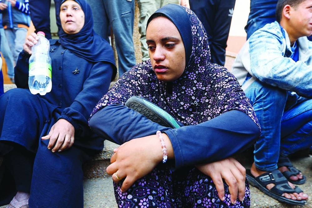 
Razan Ashram holds her husband’s shoes, who was killed in an Israeli raid, amid the ongoing conflict, during his funeral at Nasser hospital in Khan Yunis, in the southern Gaza Strip, yesterday. 