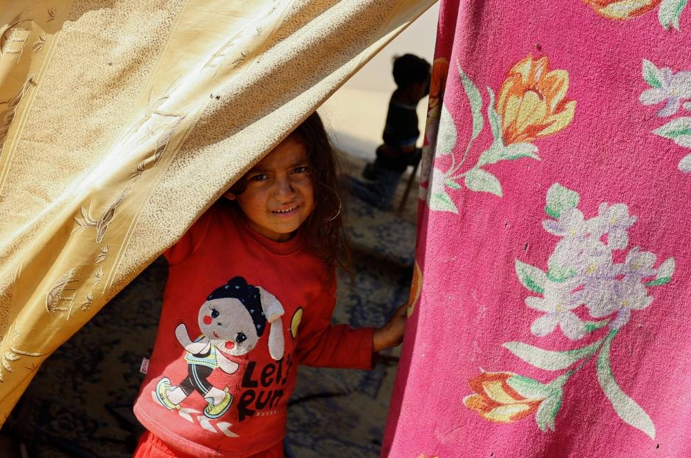 A child looks out of a tent, as displaced Palestinians, who fled their houses due to Israeli strikes, shelter in a tent camp near the border with Egypt, in Rafah in the southern Gaza Strip, on Monday. REUTERS