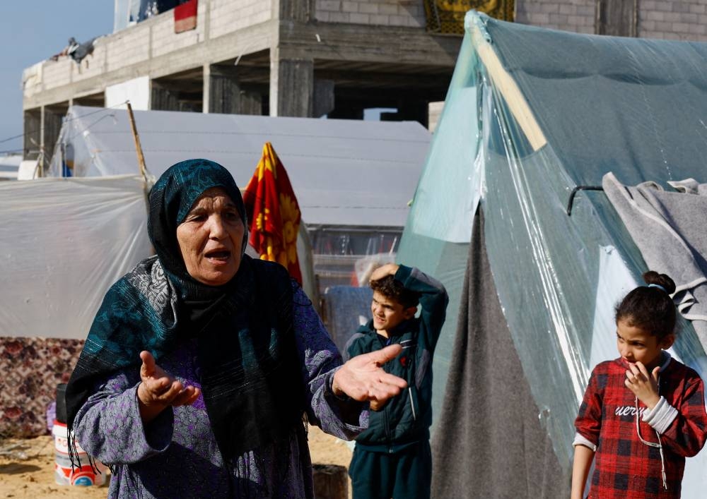 Um Nidal Al-Khwaja,  a displaced Palestinian woman gestures, as displaced Palestinians, who fled their houses due to Israeli strikes, shelter in a tent camp near the border with Egypt, in Rafah in the southern Gaza Strip, on Monday. REUTERS
