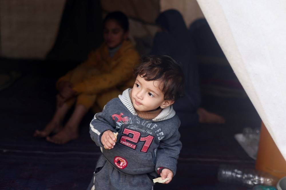A displaced Palestinian boy, who fled his house with his family due to Israeli strikes, looks out of their tent where they shelter in Rafah, in the southern Gaza Strip, on Tuesday. REUTERS