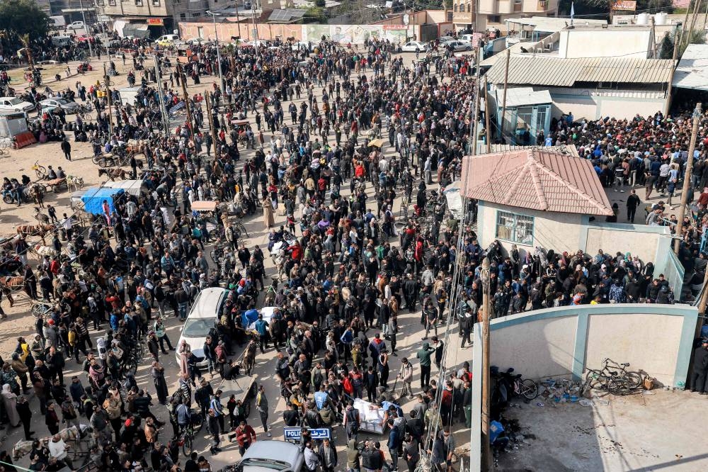 Palestinians gather to receive flour rations for their families outside a warehouse of the United Nations Relief and Works Agency for Palestine Refugees (UNRWA) in Rafah in the southern Gaza Strip, on Tuesday. AFP