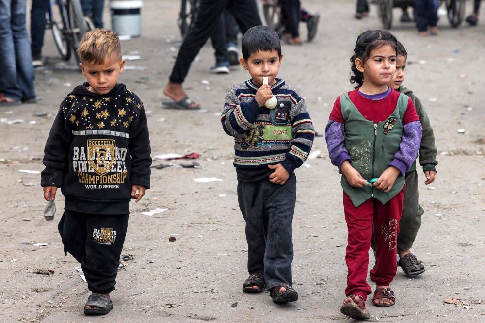 Children walk along a street in Rafah in the southern Gaza Strip, on Tuesday. AFP