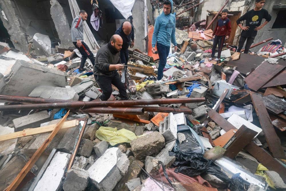 Palestinians inspect the damages amid the rubble following Israeli bombardment in Rafah in the southern Gaza Strip, on Wednesday. AFP 