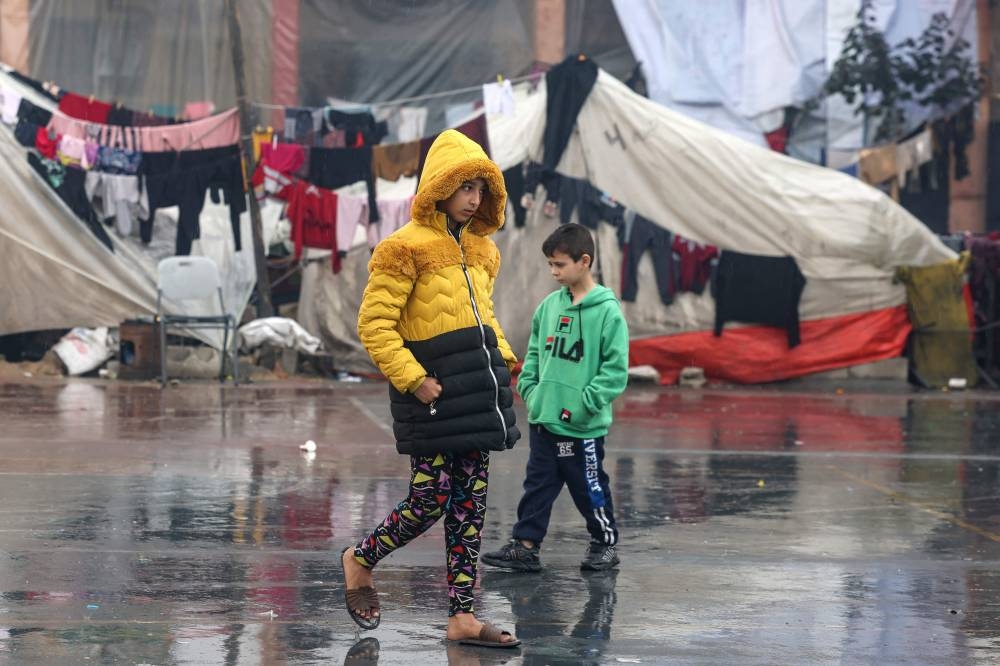 Palestinians children walk near makeshift tents at a camp set up on a schoolyard in Rafah in the southern Gaza Strip where most civilians have taken refuge, on Wednesday. AFP 