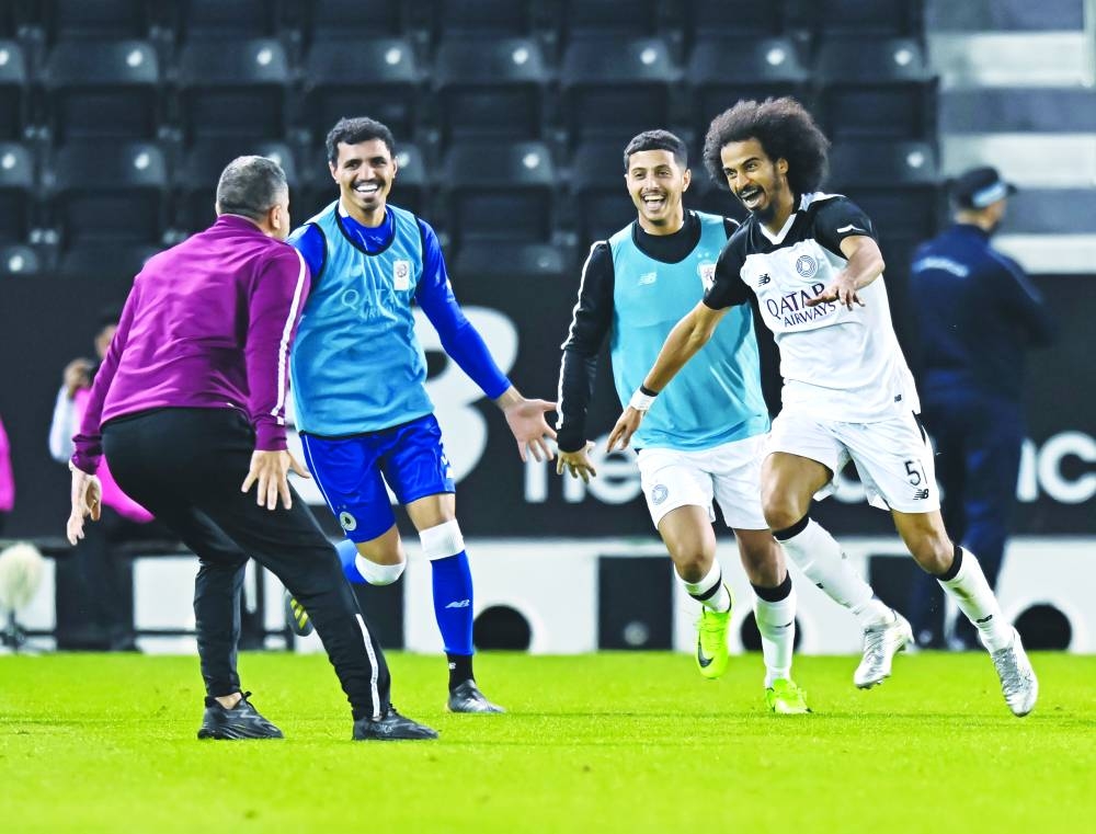 
Al Sadd’s Akram Afif (right) celebrates with teammates and coach Wesam Rizik (left) after scoring against Al Duhail in the Expo Stars League yesterday. PICTURES: Noushad Thekkayil 