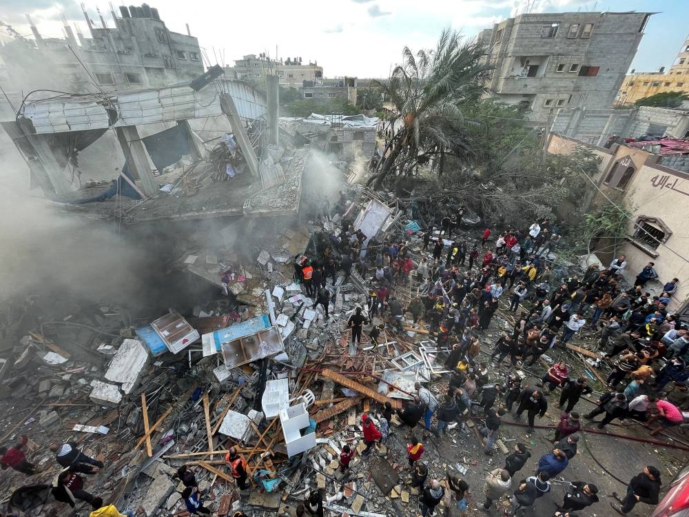 Palestinians inspect the site of an Israeli strike on a house, in Rafah in the southern Gaza Strip, on Thursday. REUTERS