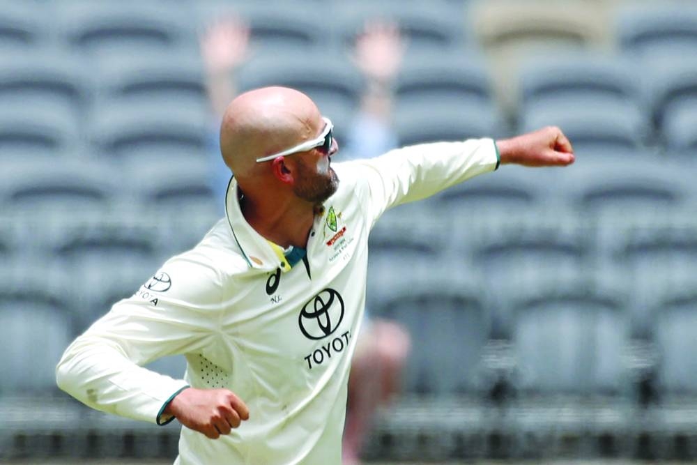 Australia’s Nathan Lyon celebrates after taking the wicket of Pakistan’s Imam-ul-Haq during day three of the first Test in Perth on Saturday. (AFP)