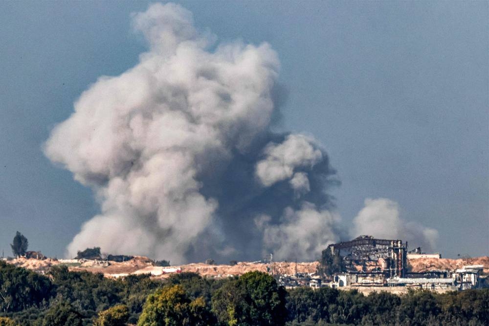A smoke plume erupts during Israeli bombardment on the northern Gaza Strip near the border with southern Israel, on Sunday. AFP