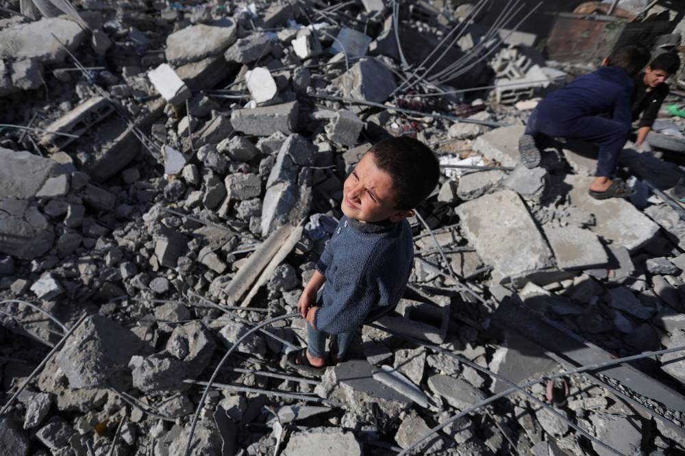 Palestinian children stand and inspect at the site of an Israeli strike on a house in Rafah, in the southern Gaza Strip, on Sunday. REUTERS