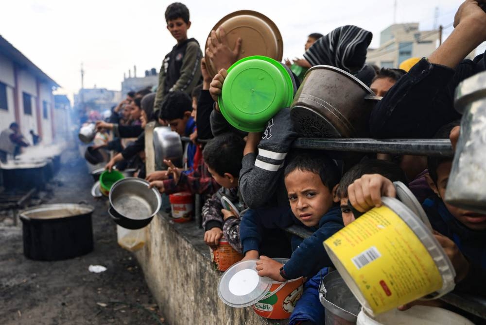 Palestinians children wait to collect food at a donation point in a refugee camp in Rafah in the southern Gaza Strip, on Saturday. AFP