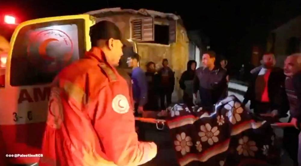 A wounded Palestinian is carried into an ambulance following Israeli strikes at a location given as Deir al-Balah, Gaza in this screenshot taken from a handout video released on Friday.  Palestine Red Crescent Society/Handout via REUTERS