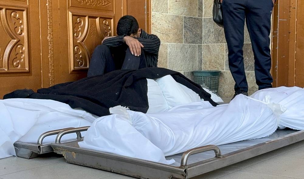 A mourner reacts next to the bodies of Palestinians killed in Israeli strikes at Nasser hospital in Khan Younis, in the southern Gaza Strip, on Saturday. REUTERS