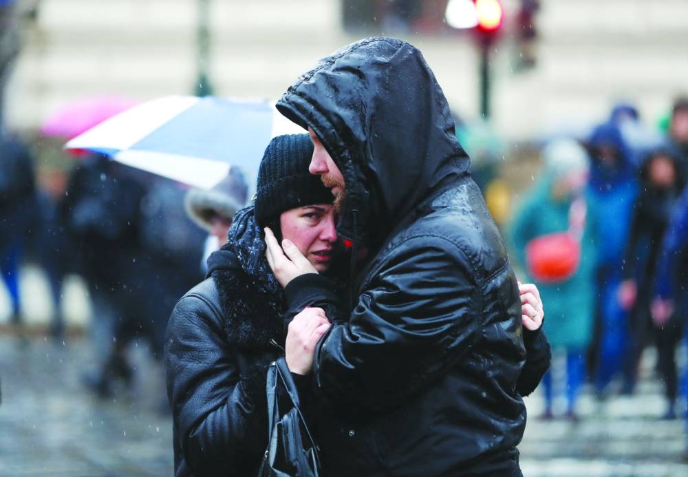 People comfort each other as they observe a minute of silence commemorating the victims of a shooting at one of Charles 
University’s buildings in Prague on Saturday.
