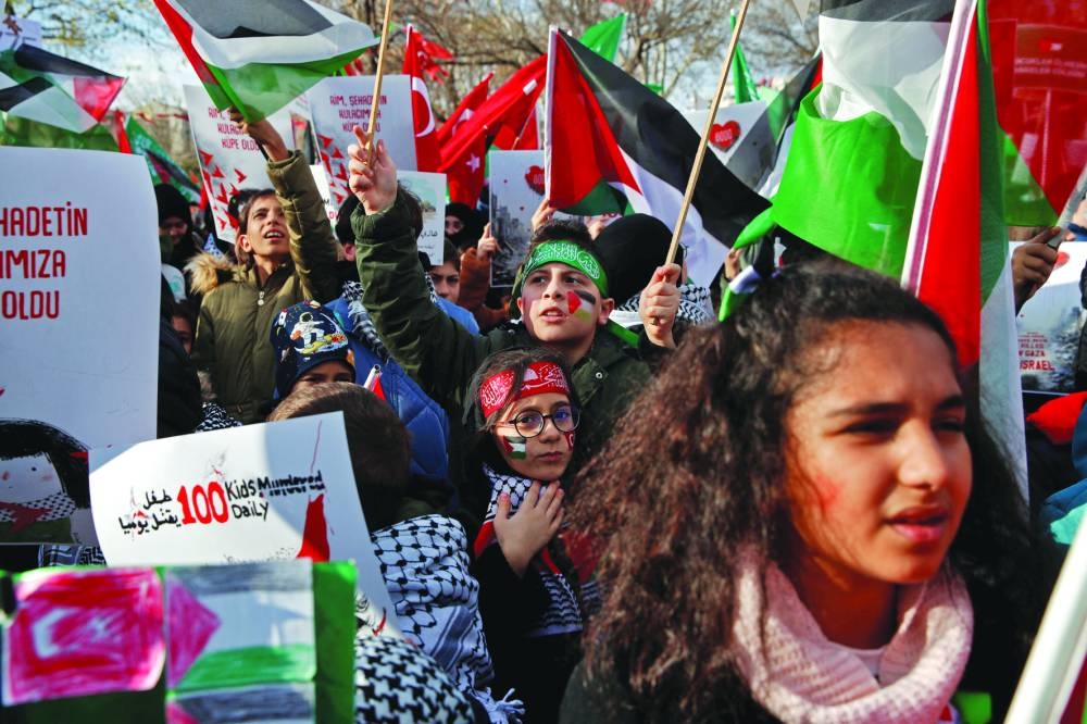 
Palestinians collect food at a donation point in a refugee camp in Rafah in the southern Gaza Strip, yesterday, amid continuing battles between Israel and Hamas. Right: Children take part in a demonstration in solidarity with Palestinian children in Gaza Strip, in Istanbul, Turkiye, yesterday. 