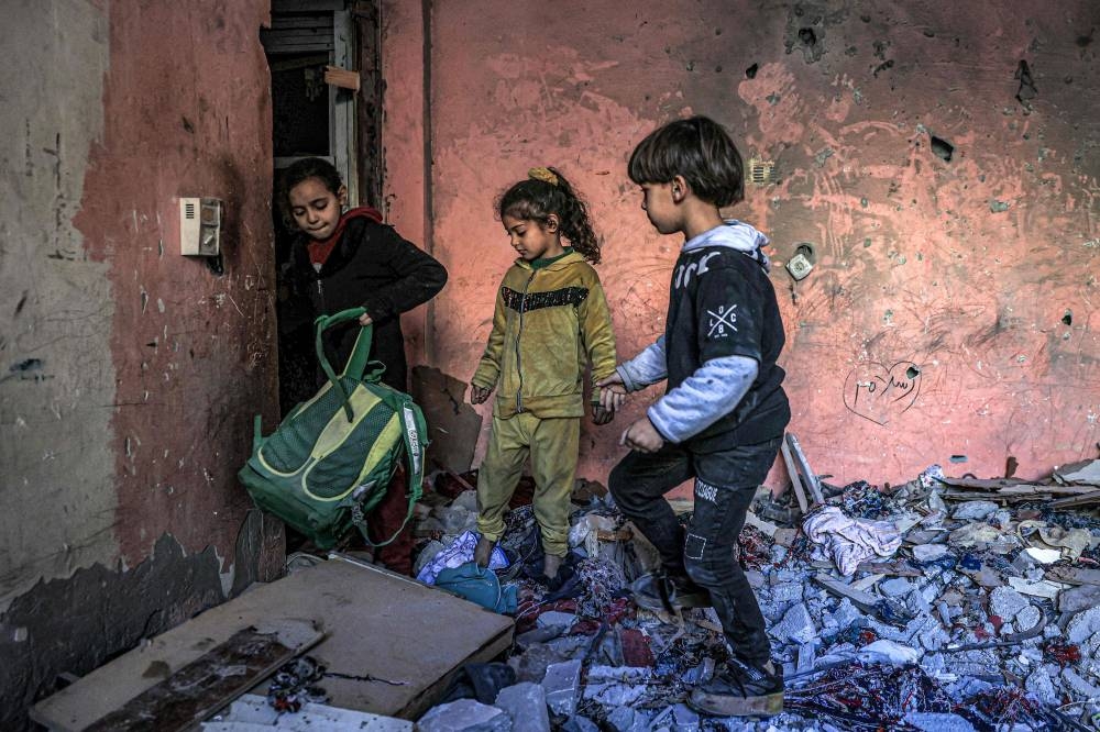 Children inspect items in the rubble in a room overlooking a building destroyed by Israeli bombardment in Rafah in the southern Gaza Strip, on Sunday. AFP