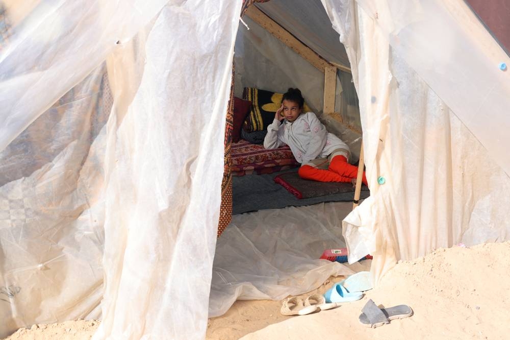 A displaced Palestinian girl, who fled her house due to Israeli strikes, shelters in a tent camp, in Rafah in the southern Gaza Strip, on Sunday. REUTERS