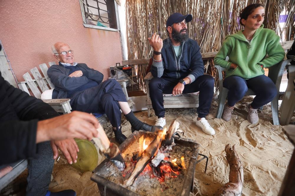 Hazem Saba, a displaced Palestinian Christian who fled his house due to Israeli strikes, sits with his wife Ghada and his father in law on Christmas Day, in Rafah in the southern Gaza Strip, on Monday. REUTERS